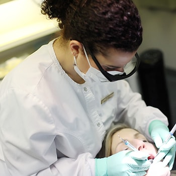 A dentist cleaning a patient's teeth