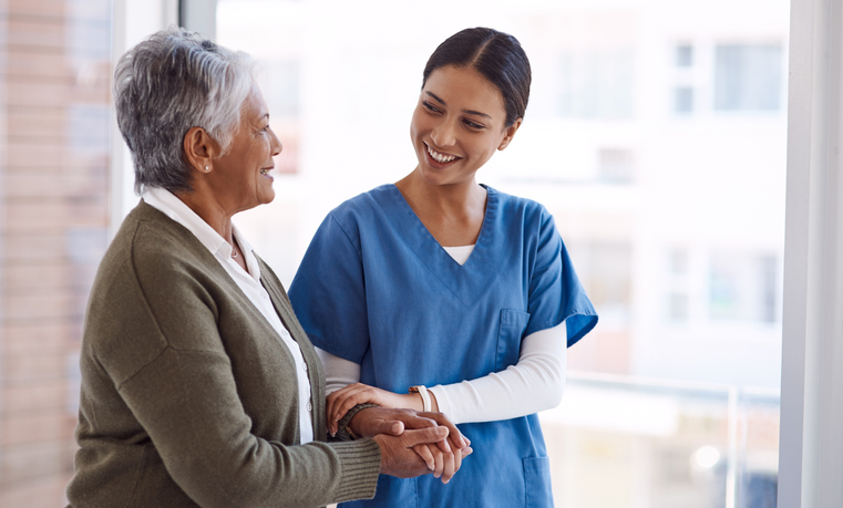 Dental staff member helping a smiling patient out of the office